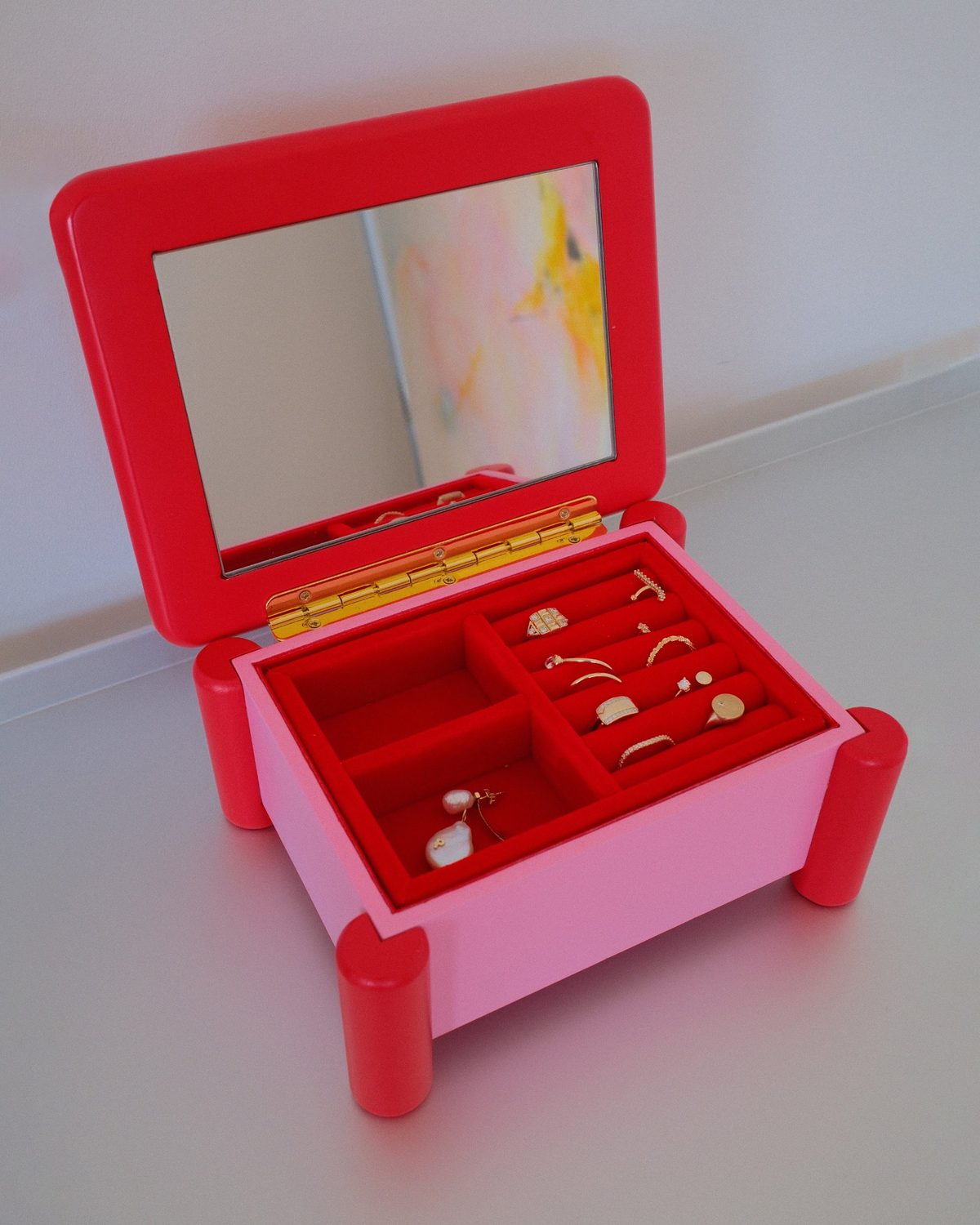 The Dot opened: a mirror in the red lid and rings and pearl earrings on red velvet