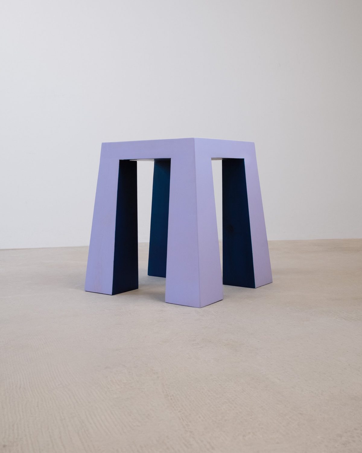 The Flare-Stool on its own: lilac outside, deep blue inside, its legs widening toward the floor
