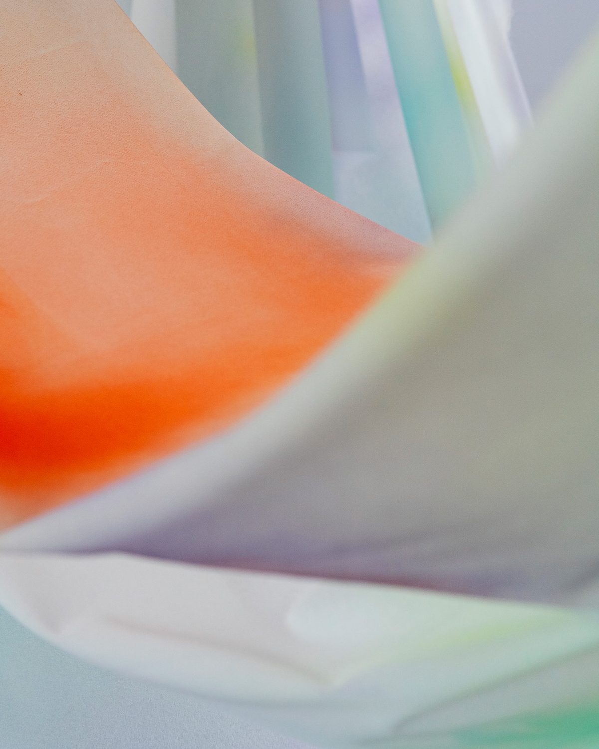 Close-up of the silk: a soft orange gradient fading into pale mint and lilac