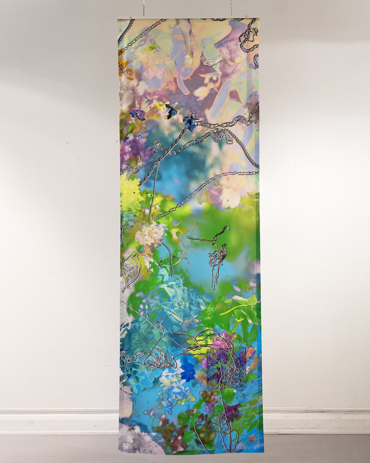 A long printed textile banner with flowers, foliage and chrome chains hanging in front of a white wall
