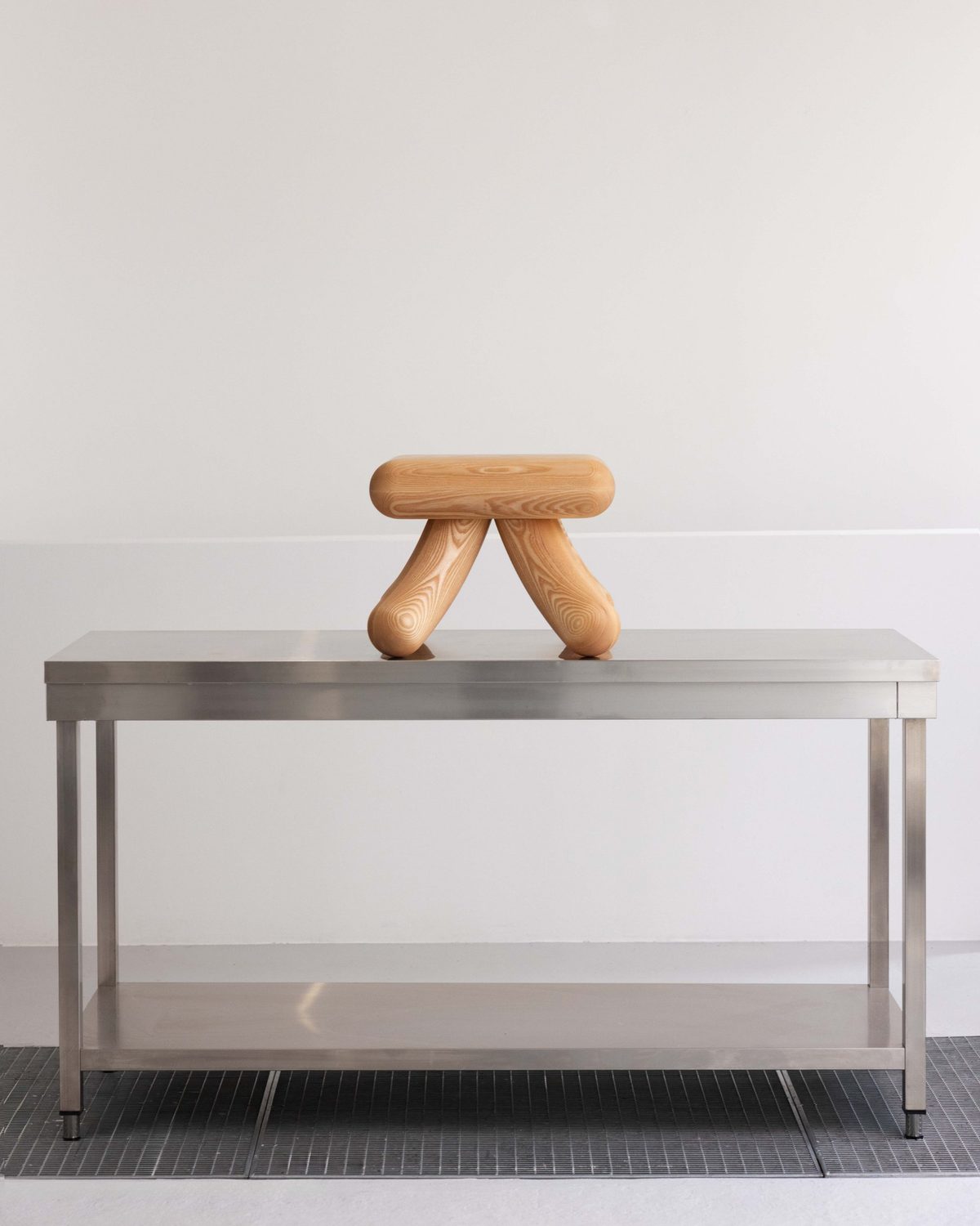 Kanji-Stool from the front on a stainless steel table, its legs forming the lower half of the tree character