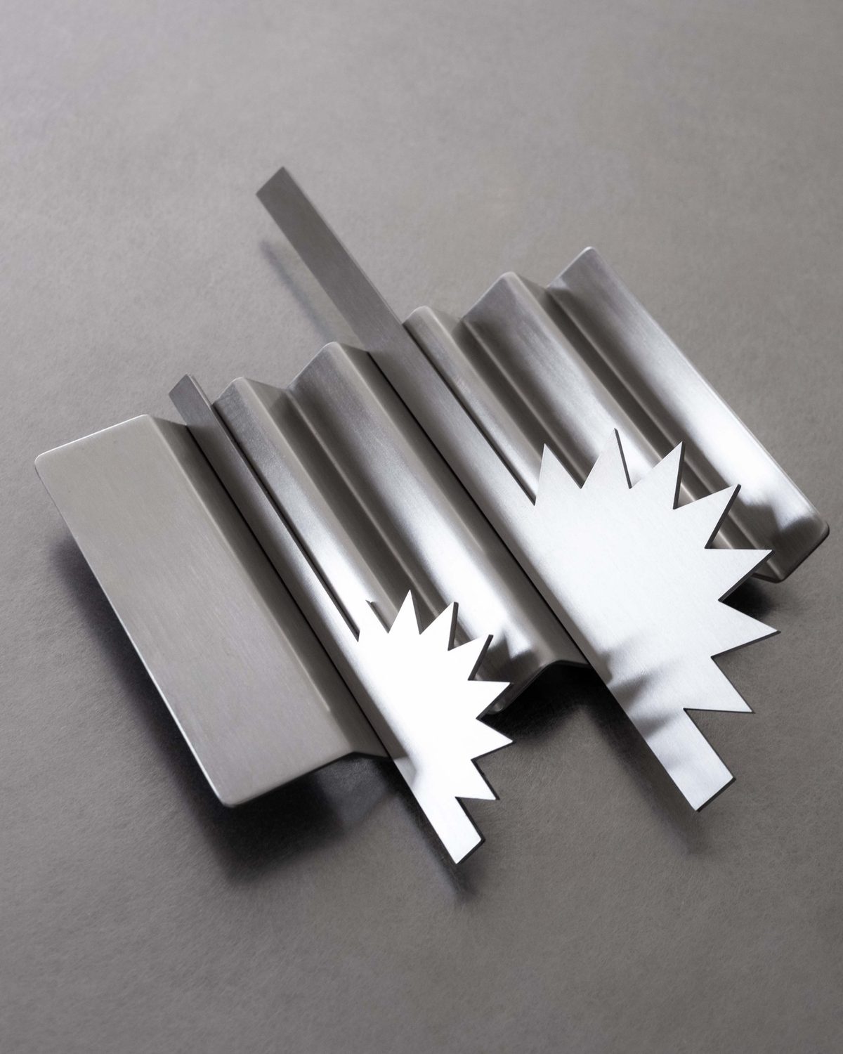 Steel cutlery with spiky star-shaped heads on a corrugated tray